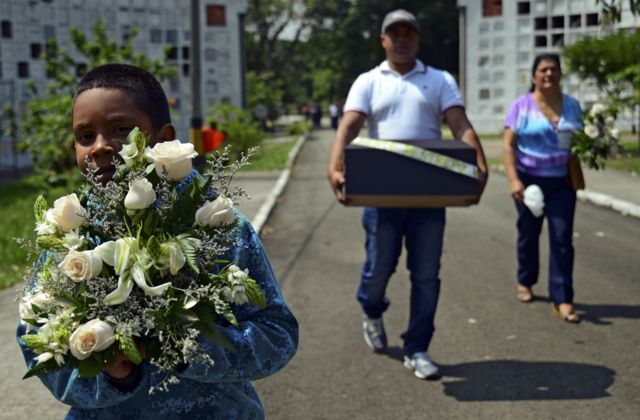 Niño carga un ramo de flores para un funeral
