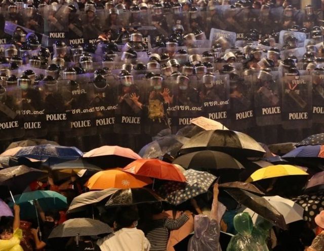 Protesters set up an umbrella to protect themselves Face the police with shield