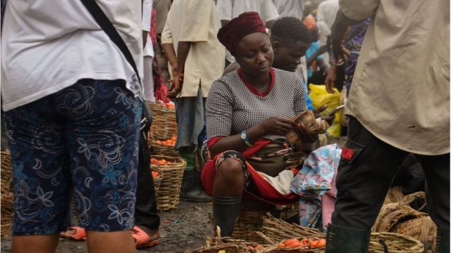 Woman selling food at a market in Nigeria