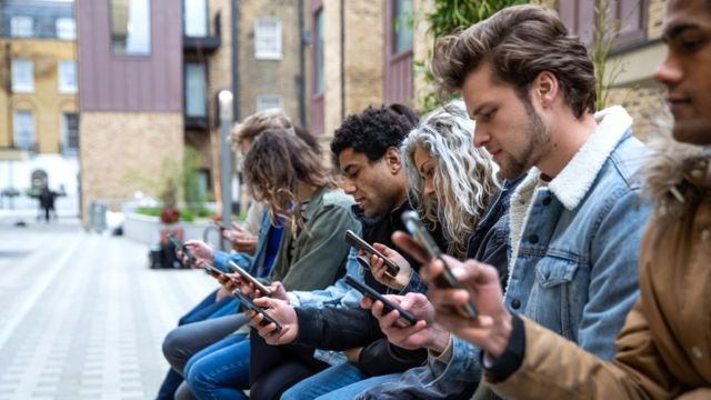 Un groupe d'amis adolescents concentrés sur leurs propres smartphones