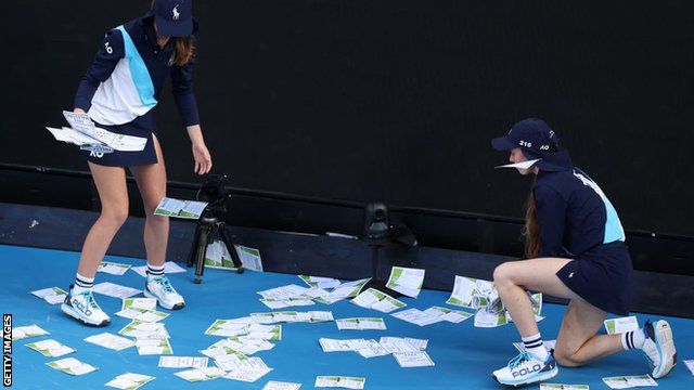 Ball kids pick up the paper