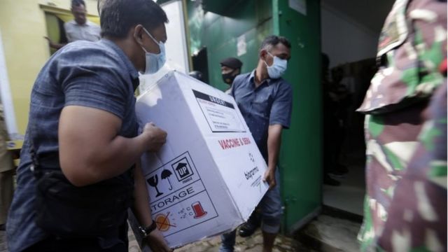 Workers unload boxes containing a COVID-19 vaccine from a truck to a storage building, upon the arrival of Sinovac"s COVID-19 vaccine in Banda Aceh, Indonesia, 12 January 2021. I