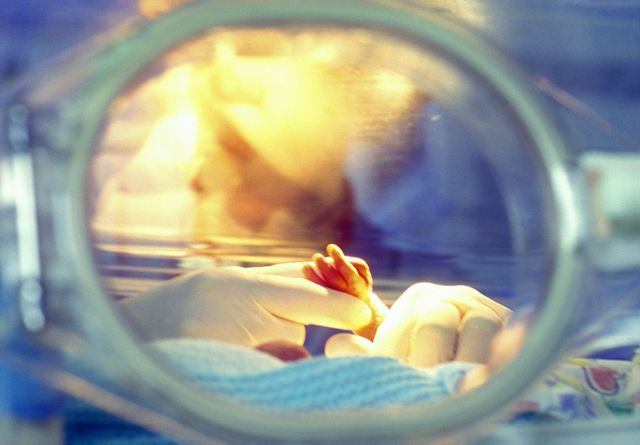 Agarrando la mano de un bebé en incubadora