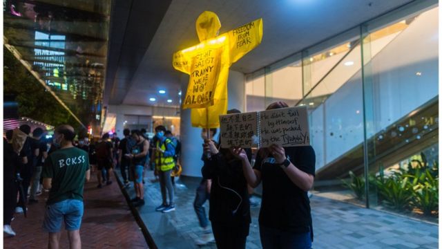 A yellow raincoat in memory of Marco Leung, the yellow raincoat man, is held by two protesters in Admiralty on June 15, 2020 in Hong Kong, China. (Photo by Marc Fernandes/NurPhoto via Getty Images)