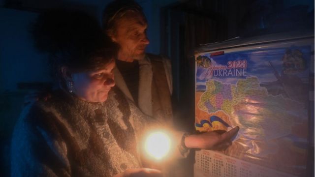 Una pareja anciana en Jersón observa un mapa de Ucrania a la luz de una vela