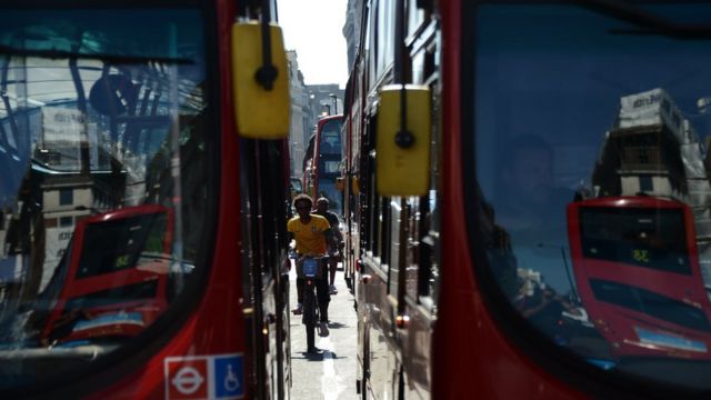 Ciclistas circulan entre dos autobuses en Londres.