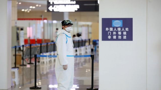Funcionario con equipo de protección personal en el aeropuerto de Nanjing, marzo 2020