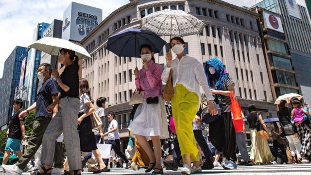 Pedestres caminham em rua no bairro de Ginza, em Tóquio