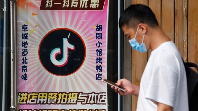 رجل أمام مطعم في بكين يقدم خصما لأي شخص ينشر مقاطع فيديو على تيك توك