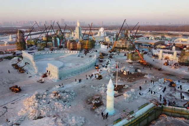 عمال يبنون هياكل جليدية في موقع مهرجان هاربين الدولي للجليد والثلج