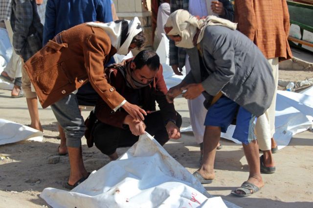 رجال ينقلون جثث قتلى الغارة التي استهدفت سجنا في صعدة شمالي اليمن