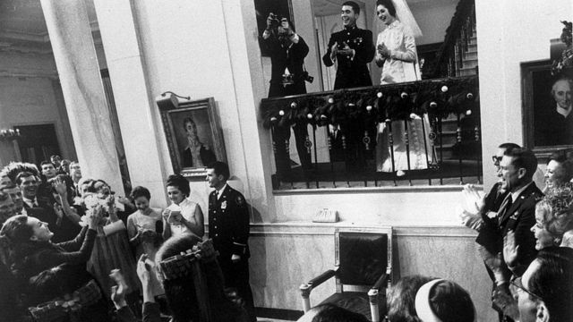 خادمة الشرف تمسك بباقة الورد في حفل في غرفة الطعام الحكومية بعد حفل زفاف تشارلز روب وليندا جونسون