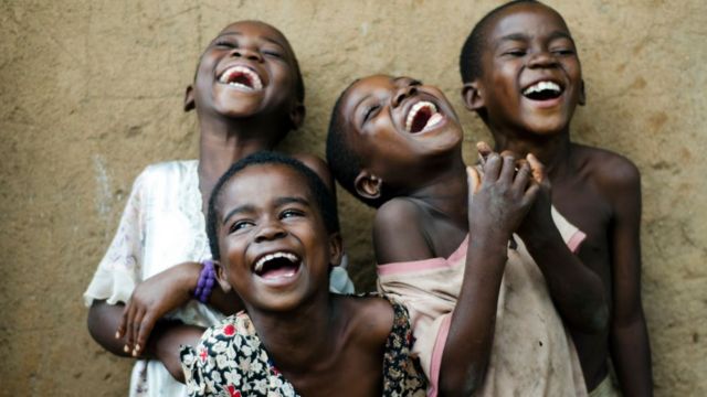Quatre enfants qui lèvent les yeux, sourient et rient au Malawi