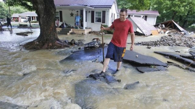 Mark Bowes, of White Sulphur Springs W. Va., makes his way to the road as he cleans up from severe flooding.
