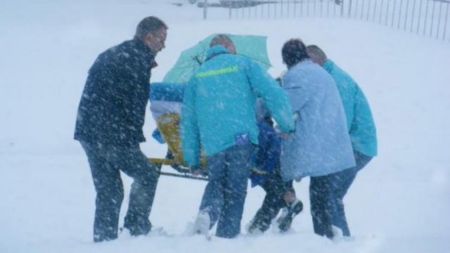 Kees Veldboer movendo um paciente em uma maca durante neve forte