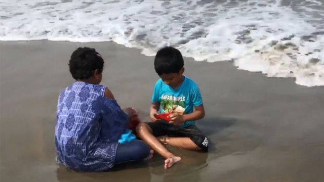 সৈকতে খেলা করছে দুটি শিশু