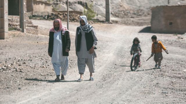 Жители деревни идут по дороге