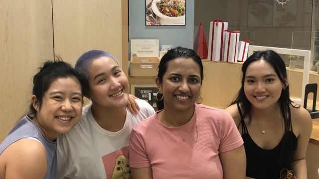 Stephanie sits together with three other Asian women who form her leadership team.