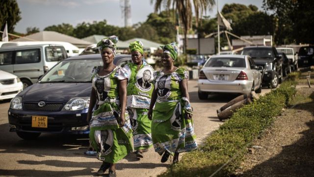 Women wearing dresses with the portrait of late Zambian President Michael Sata arrive at a memorial service in Lusaka, Zambia, on November 10, 2014, on the eve of Sata's State funeral