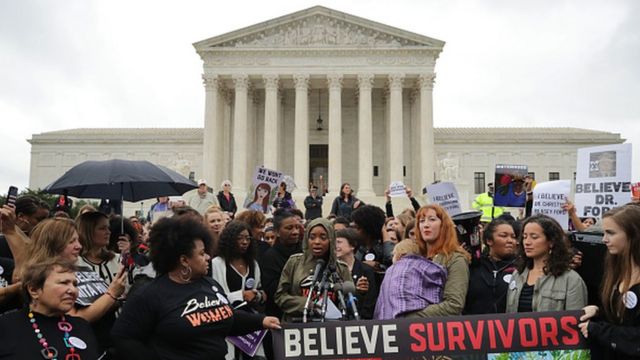Women's March protesters holding signs saying "Believe survivors" outside of the US Supreme Court.