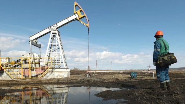 An oil industry worker near an oil pumpjack in Russia