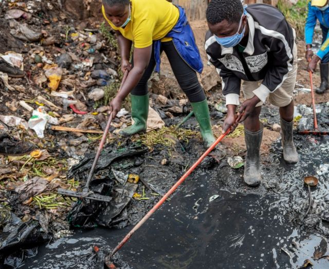 Jack Omonoi (in black jacket) working cleaning a sewer in Nairobi, Kenya