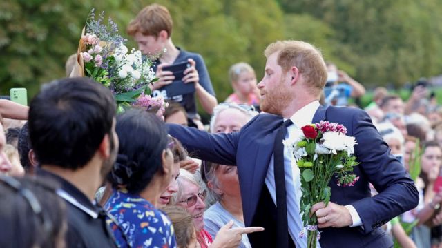 El príncipe Harry saluda al público que rindió homenaje a la reina Isabel II