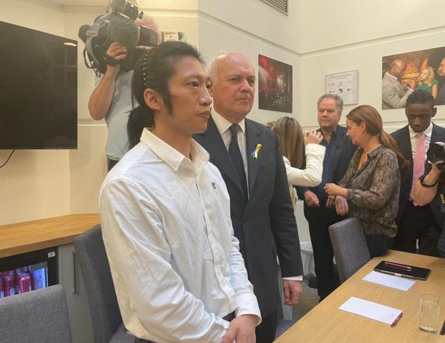 事件中受伤的30多岁港人Bob Chan在周三（10月19日）出席了英国议会多名议员举行的记者会，他身旁是保守党前党魁伊恩·邓肯-史密斯（Iain Duncan Smith，施志安）。(photo:BBC)