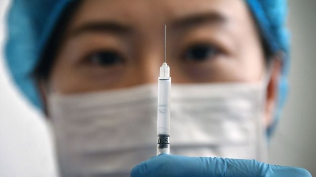 A medical worker shows a syringe with the Sinovac Biotech vaccine