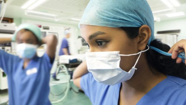 Profesionales de la salud se colocan mascarillas en un hospital
