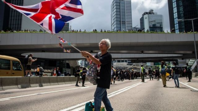 A woman holds a UK flag during a protest in Hong Kong in 2019