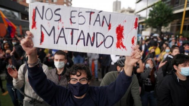 Manifestante en Bogotá con un letrero que dice "Nos están matando".
