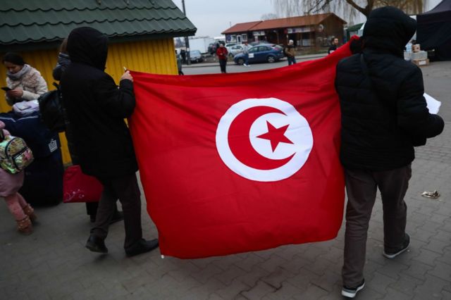 أشخاص يحملون علم تونس فرب الحدود الأوكرانية البولندية