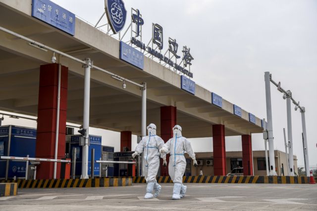 中國廣西東興口岸邊防警察身穿個人防護衣物走向工作崗位（新華社圖片8/1/2022）
