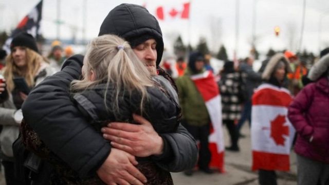 Casal se abraça em meio a protestos no Canadá
