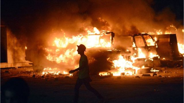 عراقي يمر أمام شاحنات عسكرية تلتهمها النيران في البصرة