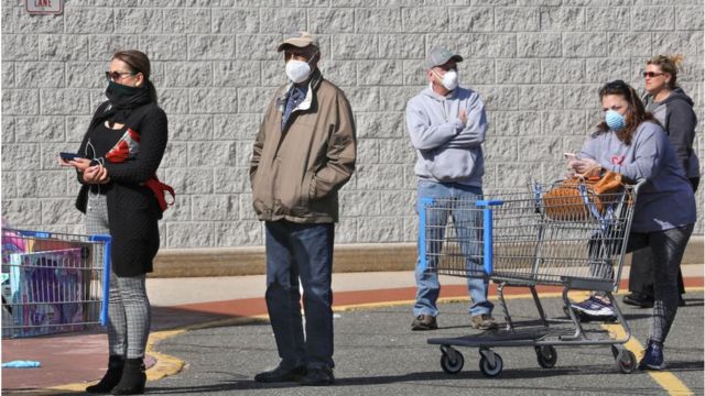 Shoppers in a line with masks on