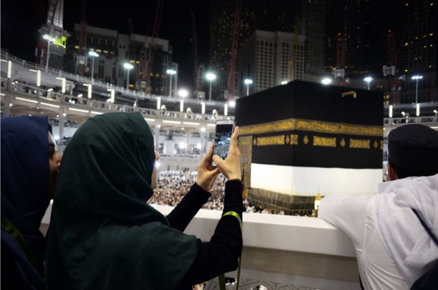 Muslim pilgrims take picture near the Islam's holiest shrine, the Kaaba, at the Grand Mosque in the Saudi holy city of Mecca, late on September 20, 2015. The annual hajj pilgrimage begins on September 22, and more than a million faithful have already flocked to Saudi Arabia in preparation for what will for many be the highlight of their spiritual lives.