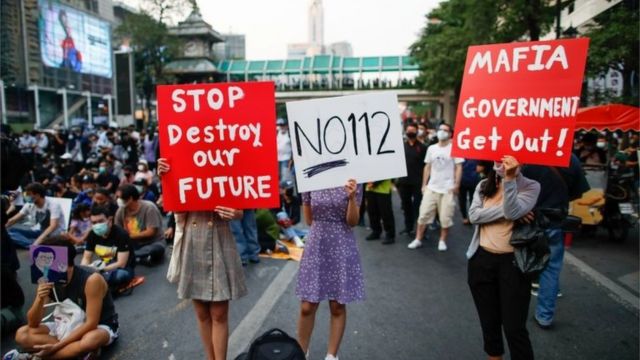 Pro-democracy protesters hold signs during a rally demanding the release of arrested protest leaders and the abolition of 112 lese majeste law, in Bangkok, Thailand, March 24, 2021