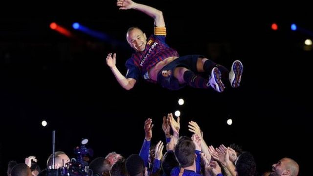 Andres Iniesta is thrown into the air by his Barcelona team-mates