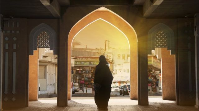 صورة ملف لسيدة عمانية تقف أمام سوق في مسقط