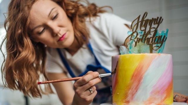 Mulher decorando bolo
