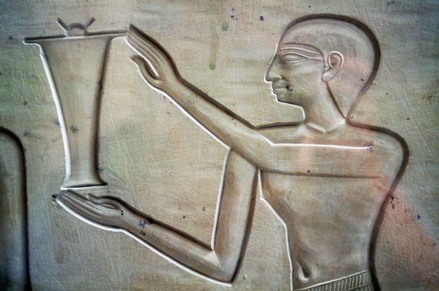 Ilustración de un hombre llevando una jarra de aceite de 2050 a.C.