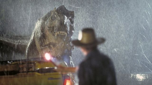 Una scena del film Jurassic Park del 1993 che mostra un T-Rex che guarda un uomo