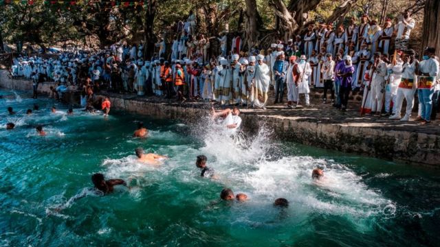 Ethiopian Orthodox Christian worshippers swim in the pool of Fasilides Bath during the celebration of Timkat, the Ethiopian Epiphany, in the city of Gondar, Ethiopia, on January 19, 2021. - Timkat is the Ethiopian Orthodox Christian festival which celebrates the baptism of Jesus in the Jordan river. The celebration has been recently declared Intangible Human Heritage by UNESCO.
