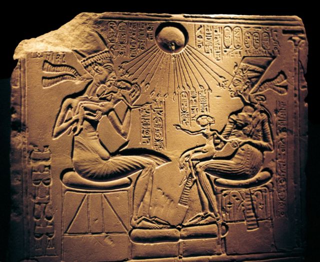 الملك أخناتون مع زوجته نفرتيتي يحميهما قرص الشمس