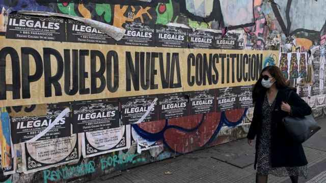 Una mujer pasa junto a un cartel de apoyo a la nueva Constitución en Santiago, el 10 de mayo de 2022.