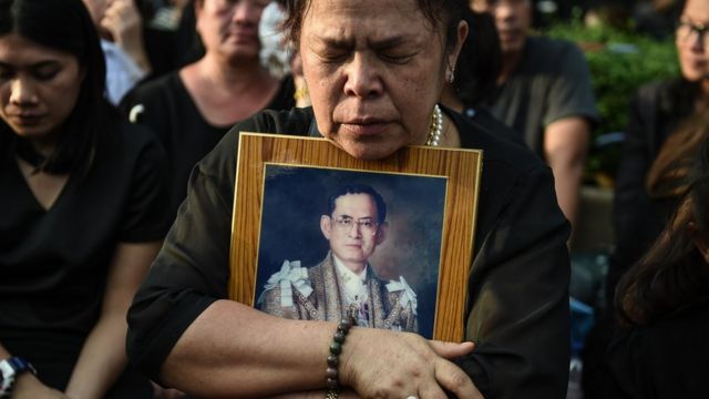 Una señora tailandesa se aferra a una fotografía del fallecido rey