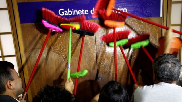 シルベイラ氏の辞任を求め同氏の部屋のドアをブラシでこする省の職員ら(30日)