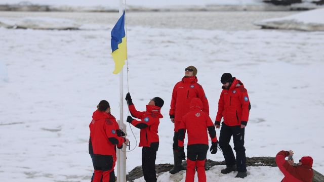 Científicos en la base ucraniana en la Antártida izando la bandera de su país